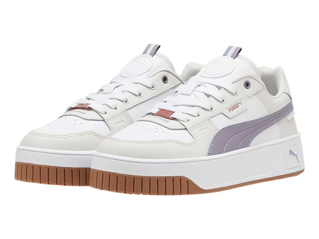 Tenis PUMA Carina Street Lux en color blanco con detalles en morado pálido y gris, con suela de plataforma blanca y café.