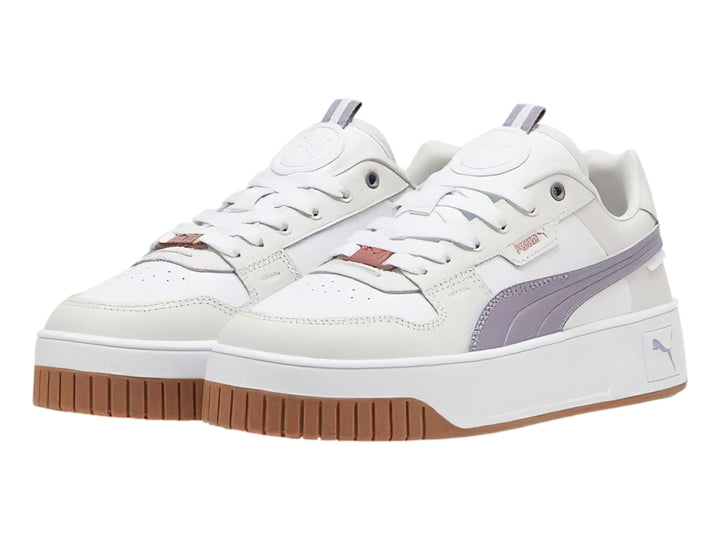 Tenis PUMA Carina Street Lux en color blanco con detalles en morado pálido y gris, con suela de plataforma blanca y café.