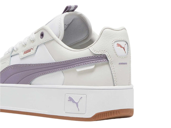 Tenis PUMA Carina Street Lux en color blanco con detalles en morado pálido y gris, con suela de plataforma blanca y café.