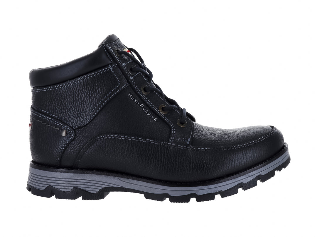 Botín de cuero negro Hush Puppies con suela gris y textura granulada.
