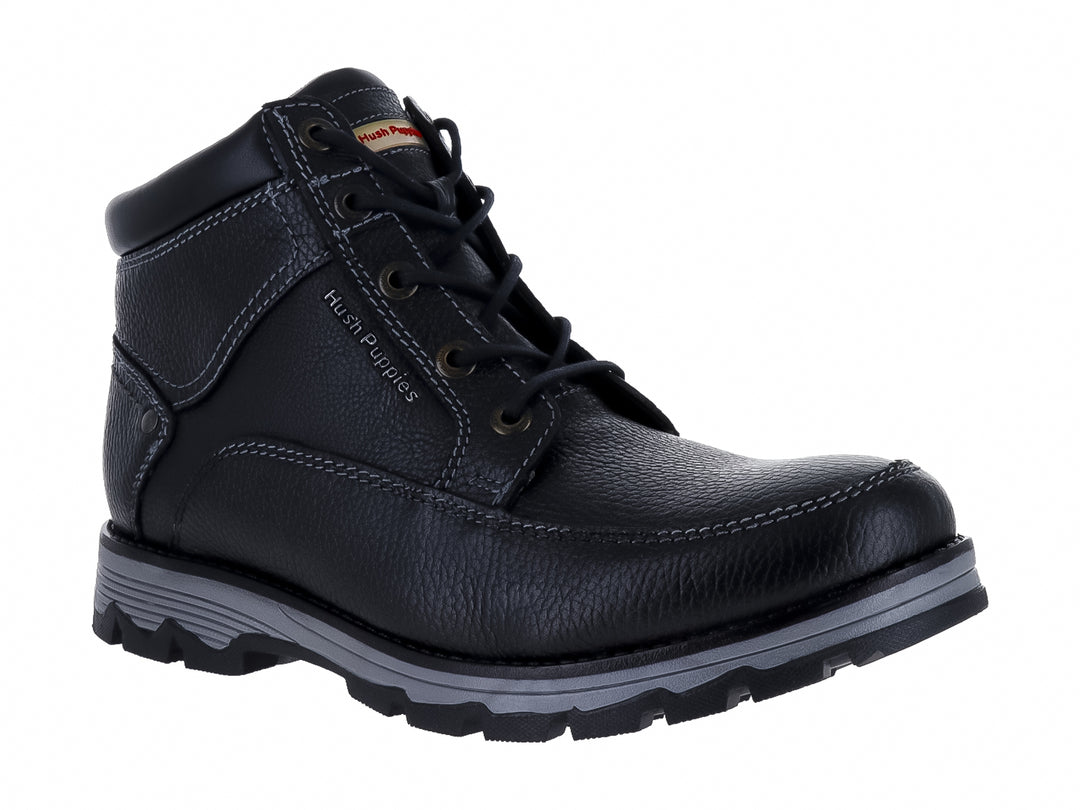 Botín de cuero negro Hush Puppies con suela gris y textura granulada.