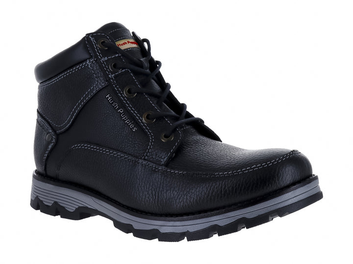 Botín de cuero negro Hush Puppies con suela gris y textura granulada.