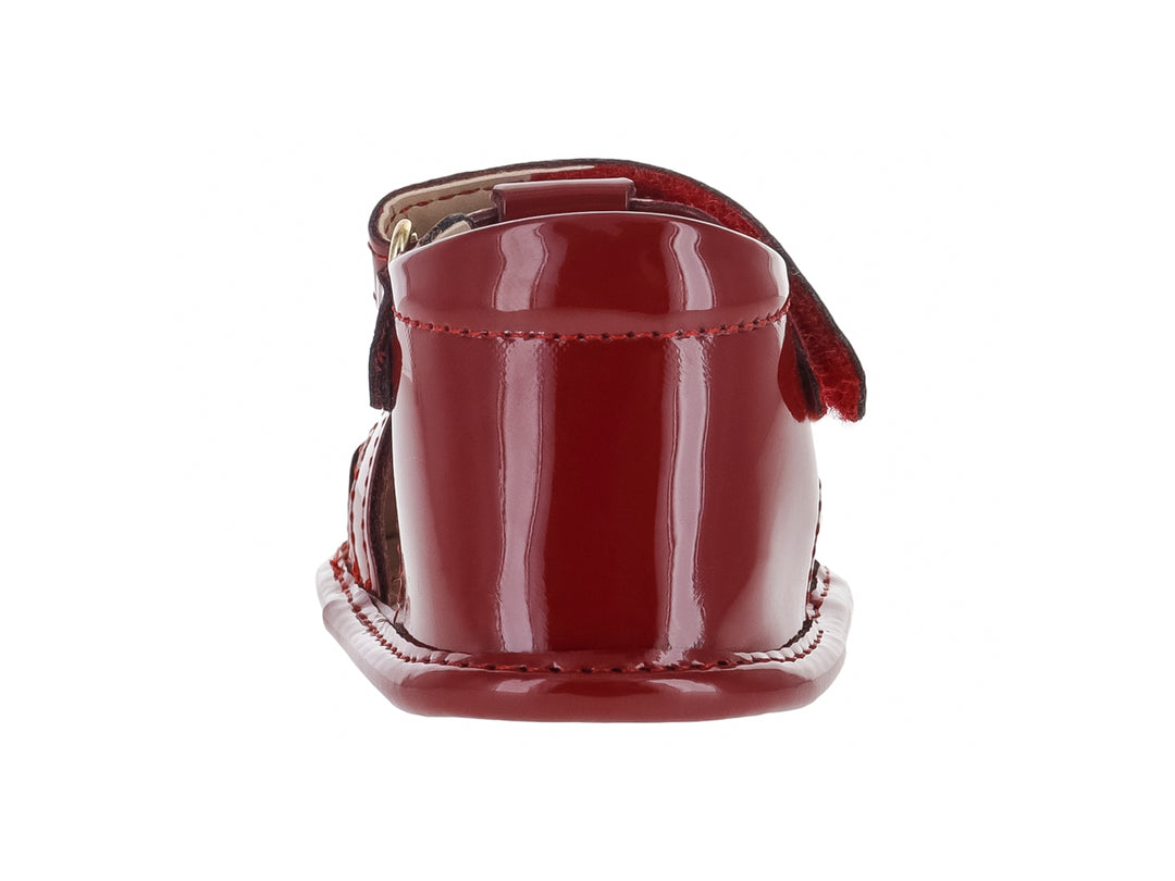 Sandalia infantil de color rojo brillante con correa ajustable y detalles decorativos.