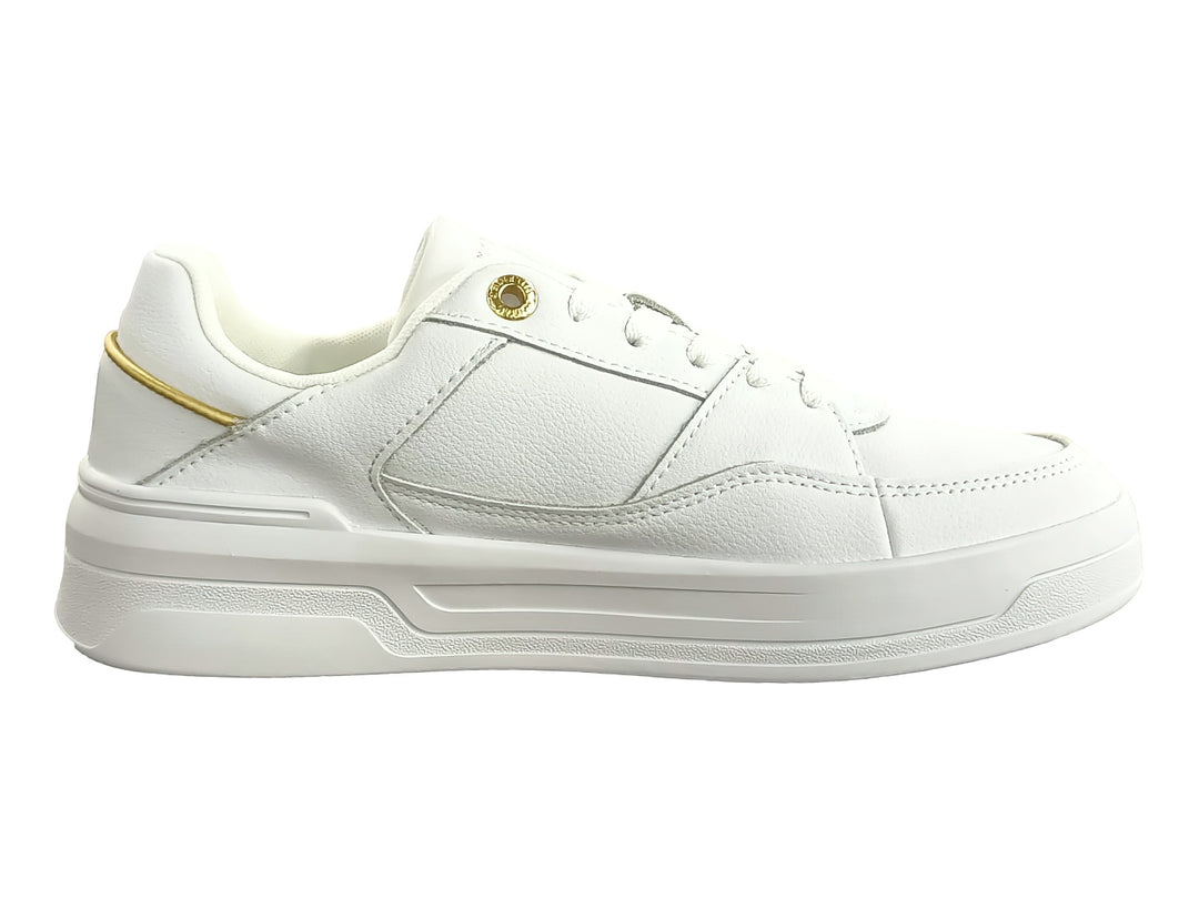 Tenis blancos Tommy Hilfiger estilo basket con detalles dorados y suela blanca ancha para mujer.