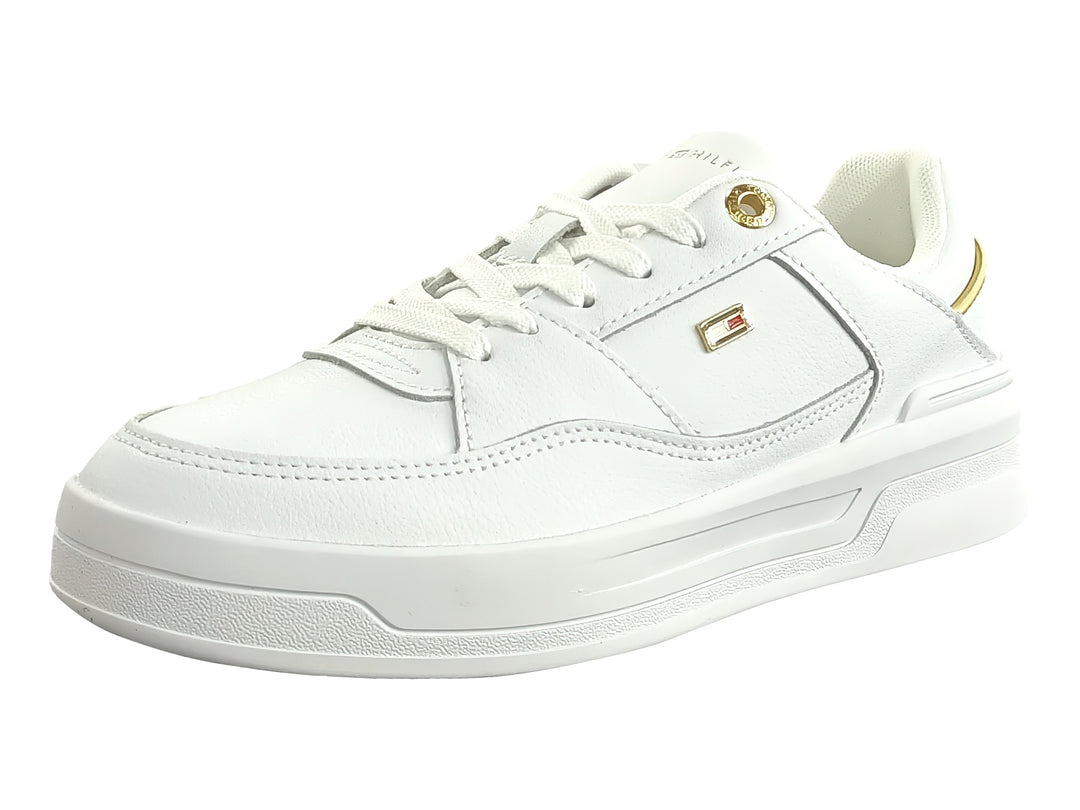 Tenis blancos Tommy Hilfiger estilo basket con detalles dorados y suela blanca ancha para mujer.