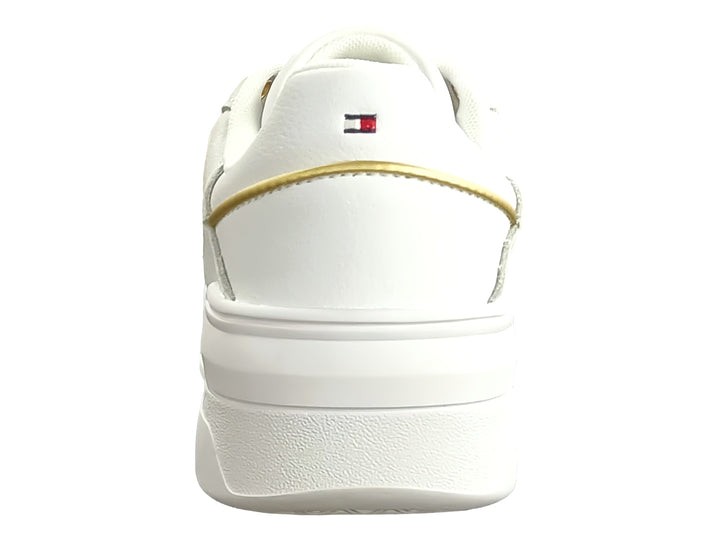 Tenis blancos Tommy Hilfiger estilo basket con detalles dorados y suela blanca ancha para mujer.