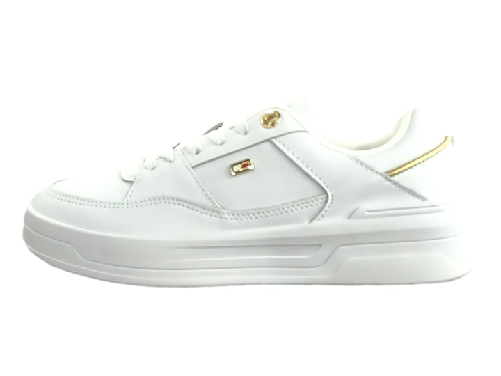 Tenis blancos Tommy Hilfiger estilo basket con detalles dorados y suela blanca ancha para mujer.