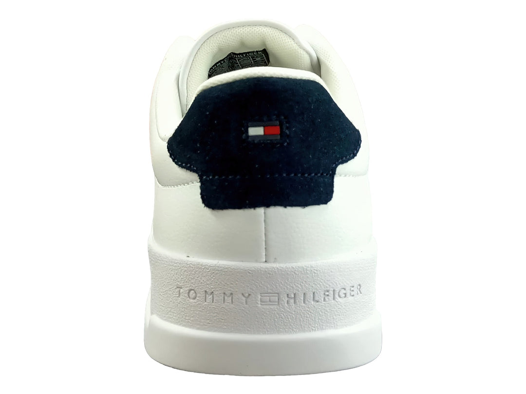 Tenis blancos de cuero con detalle azul en el talón y suela blanca.