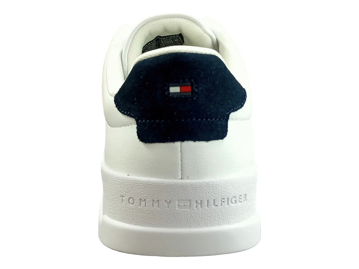 Tenis blancos de cuero con detalle azul en el talón y suela blanca.