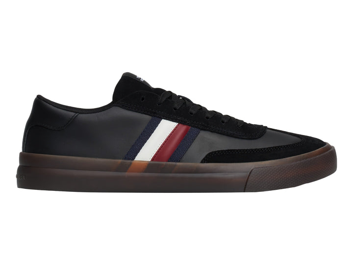 Tenis negros Tommy Hilfiger con franjas laterales tricolores y suela de goma marrón.