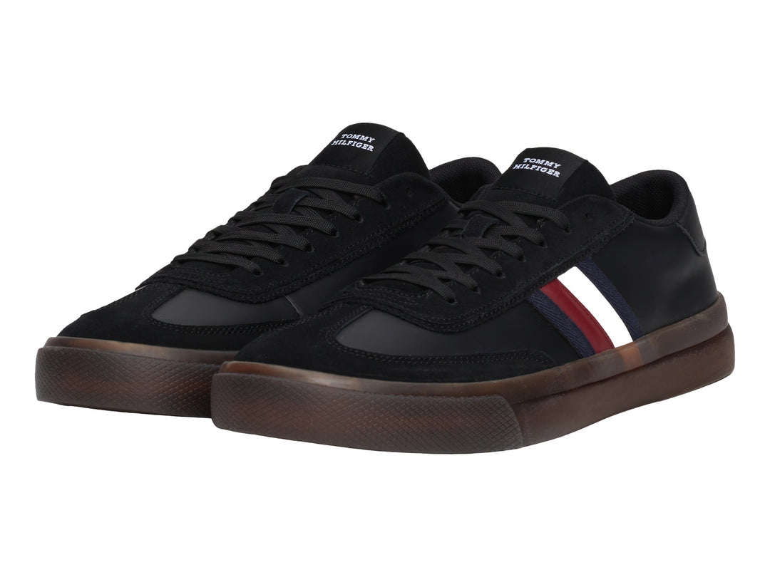 Tenis negros Tommy Hilfiger con franjas laterales tricolores y suela de goma marrón.
