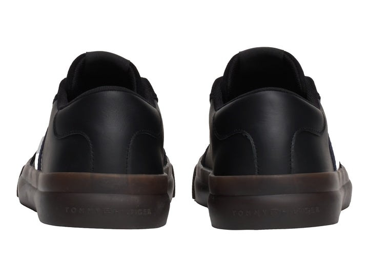 Tenis negros Tommy Hilfiger con franjas laterales tricolores y suela de goma marrón.