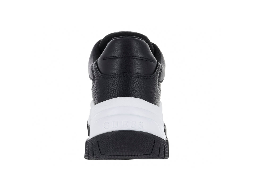 Tenis Guess negros con suela blanca de plataforma y detalles dorados.