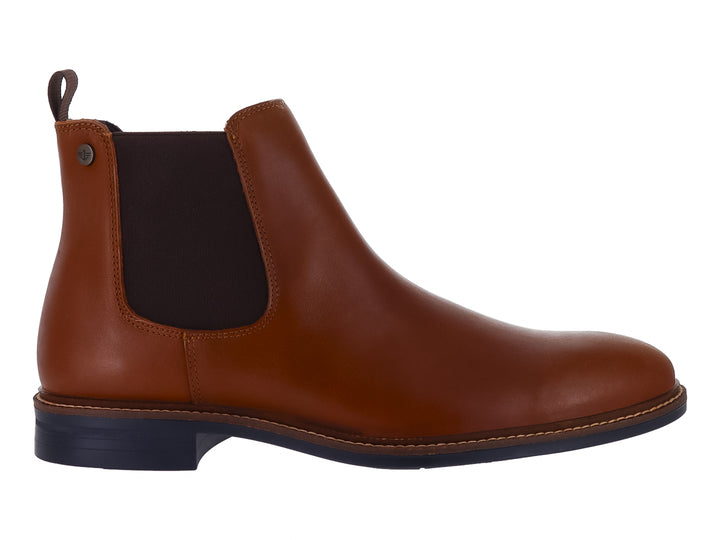Botín estilo Chelsea de cuero color cognac con suela oscura y panel elástico lateral.