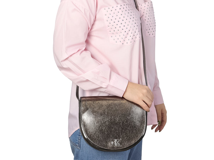 Bolso Calvin Klein modelo Ada en color gunmetal con forma semicircular y acabado metálico brillante.