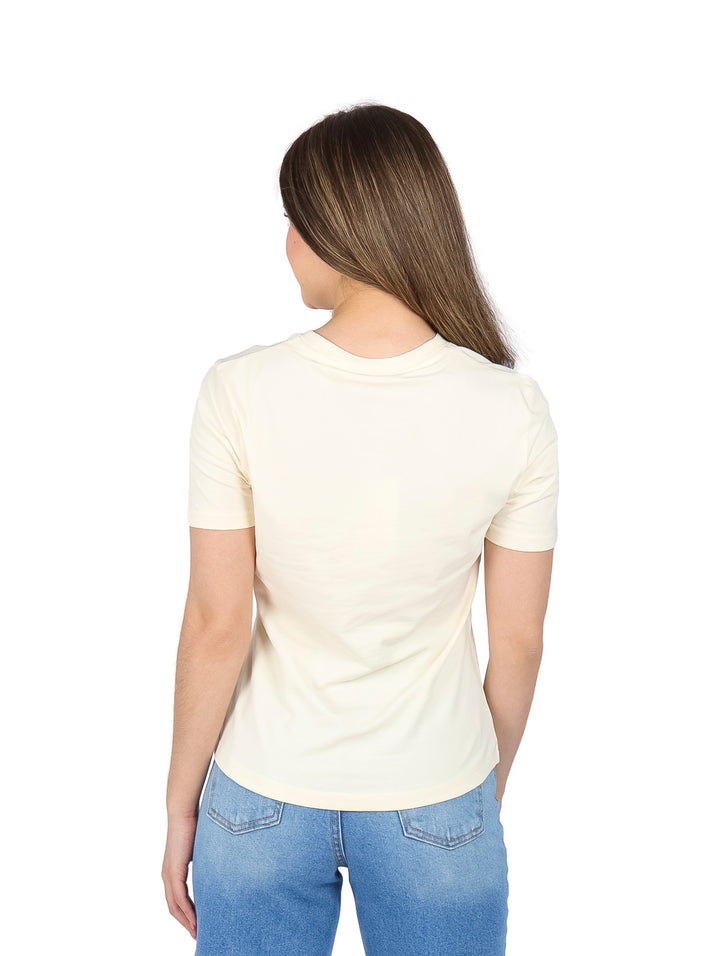 Mujer vistiendo una camiseta de manga corta color calico con logotipo azul en el pecho.