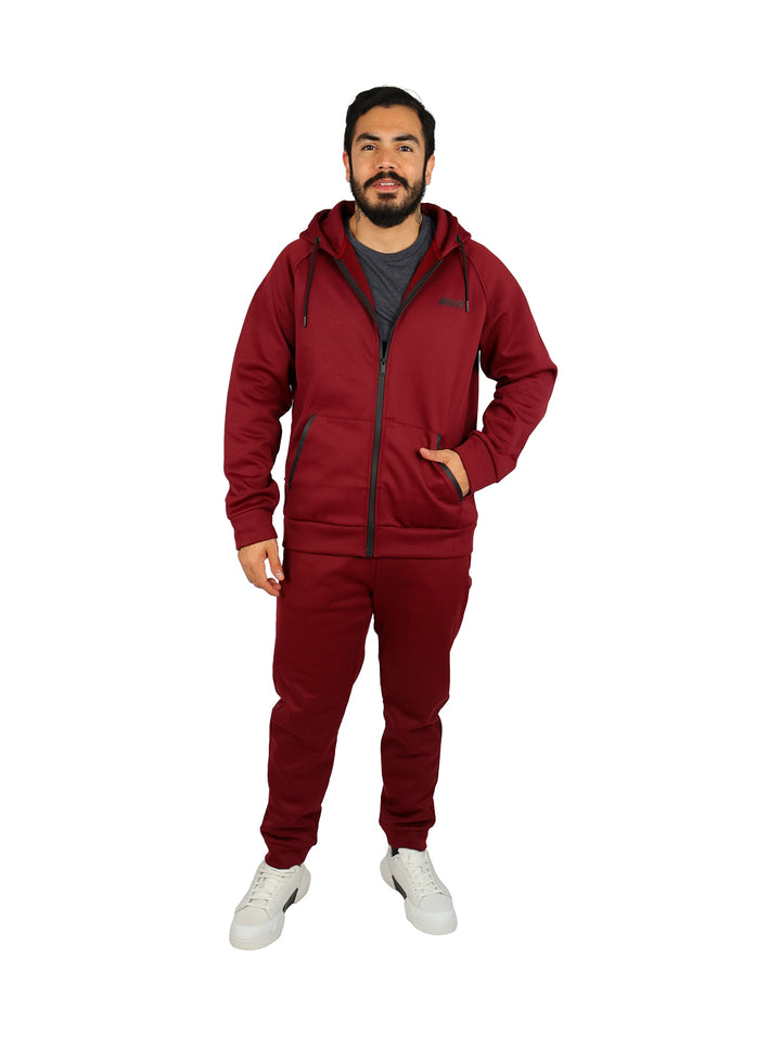 Hombre vistiendo un conjunto deportivo color burgundy compuesto por sudadera con capucha y pantalones.