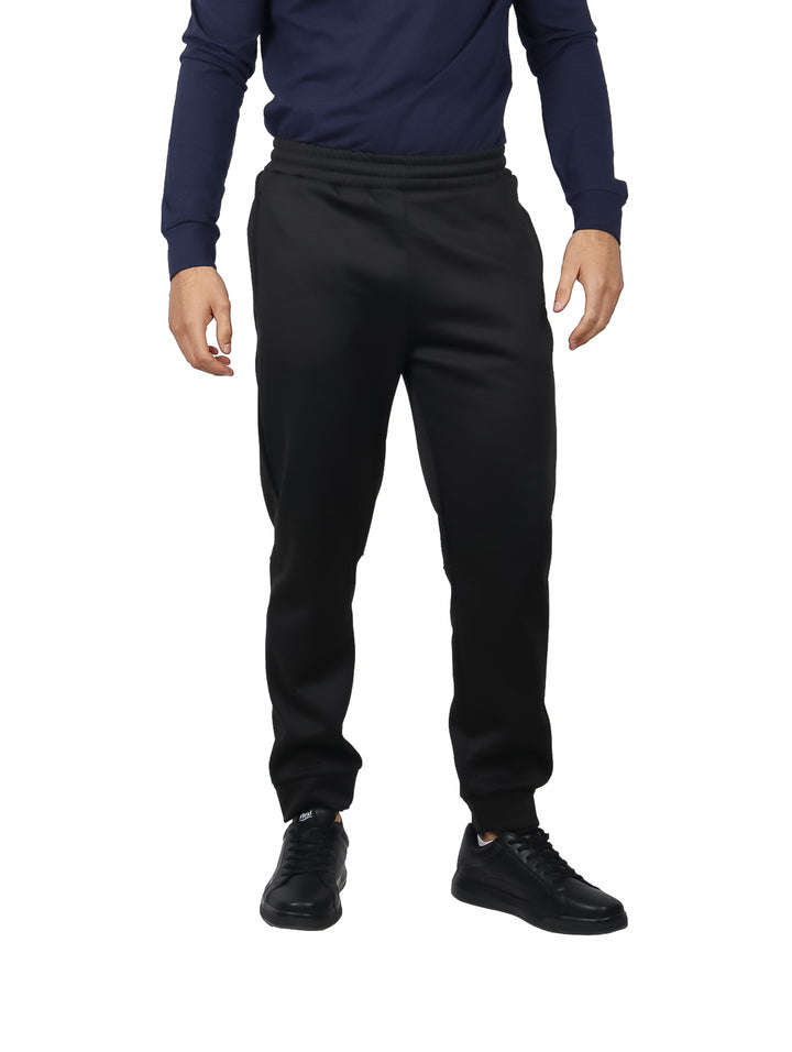 Hombre vistiendo conjunto deportivo de sudadera con capucha y pantalón en color charcoal.