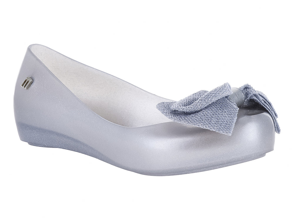 Zapato infantil Mini Melissa color plata con detalle de moño en la parte frontal.