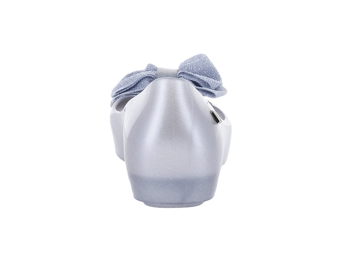 Zapato infantil Mini Melissa color plata con detalle de moño en la parte frontal.