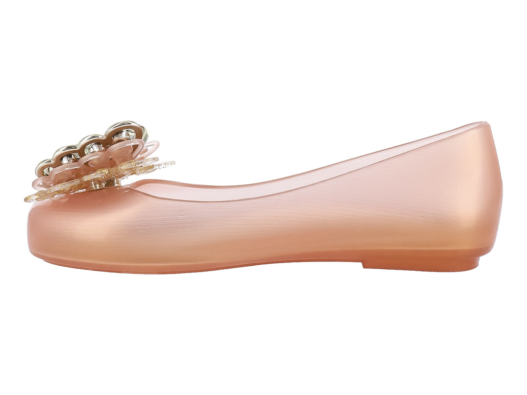 Zapato plano Mini Melissa color oro con adorno brillante en la punta.
