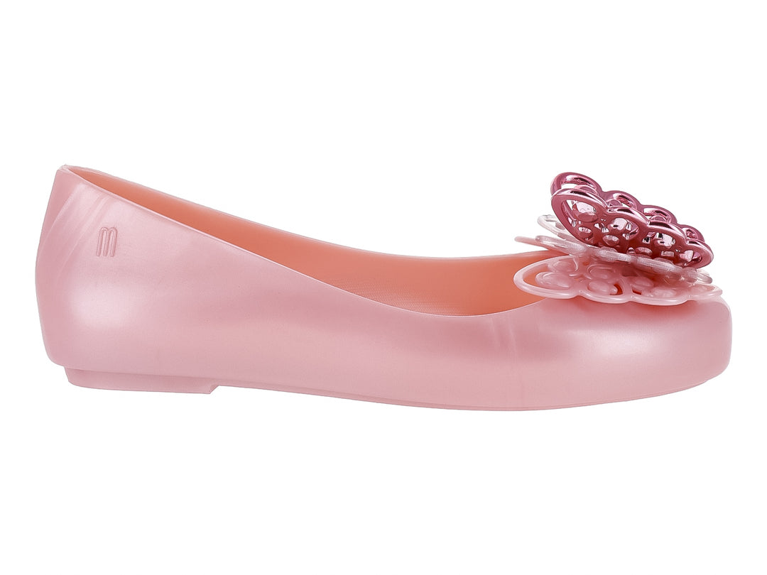 Zapato plano Mini Melissa color rosa perlado con adorno decorativo en la punta.