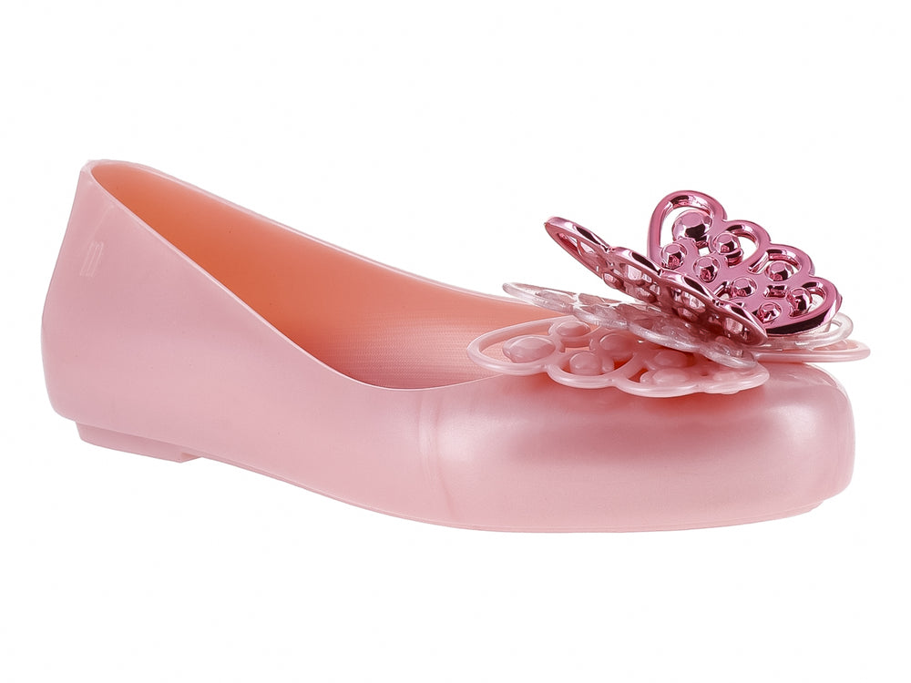 Zapato plano Mini Melissa color rosa perlado con adorno decorativo en la punta.