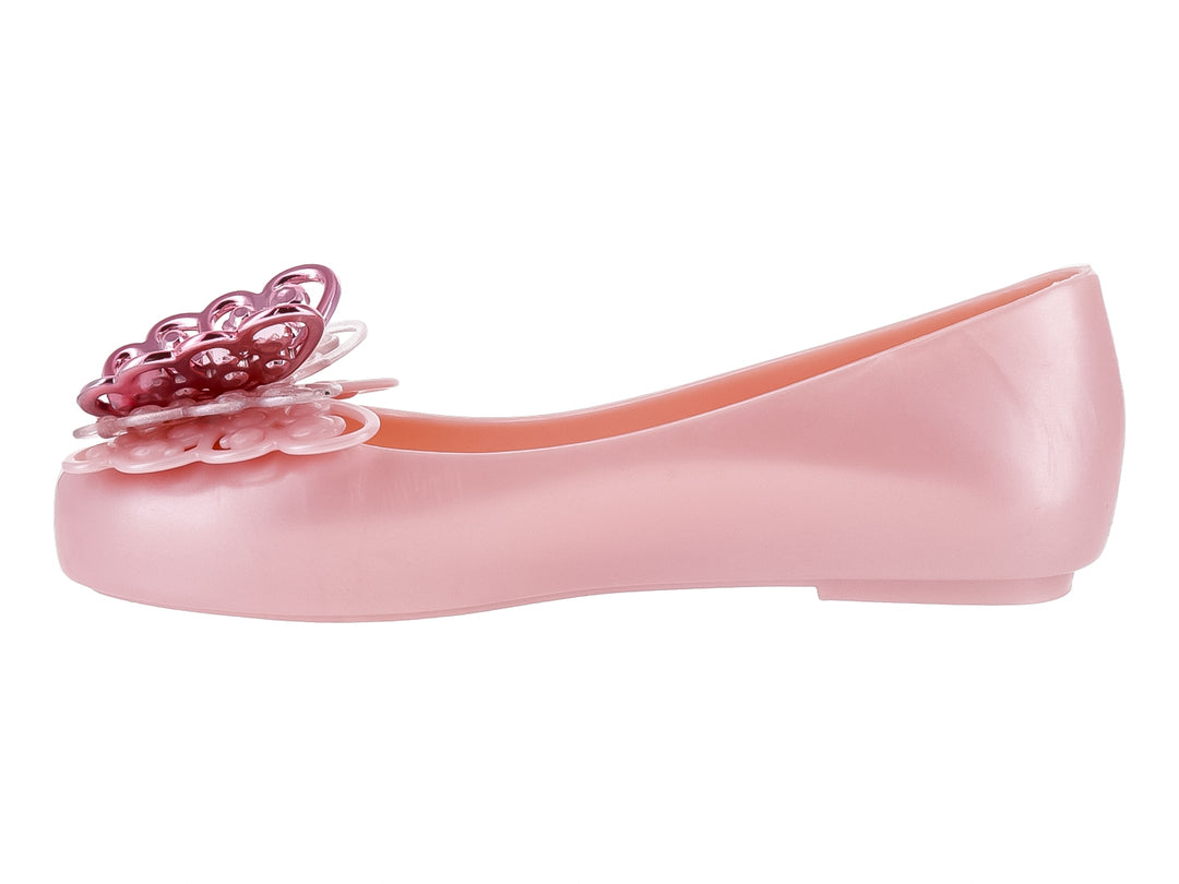 Zapato plano Mini Melissa color rosa perlado con adorno decorativo en la punta.