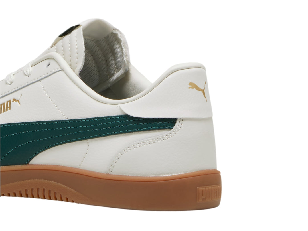 Tenis PUMA Club 5v5 color blanco con franja verde oscuro y suela de goma color café.
