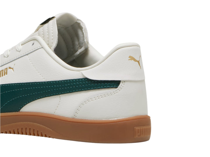 Tenis PUMA Club 5v5 color blanco con franja verde oscuro y suela de goma color café.