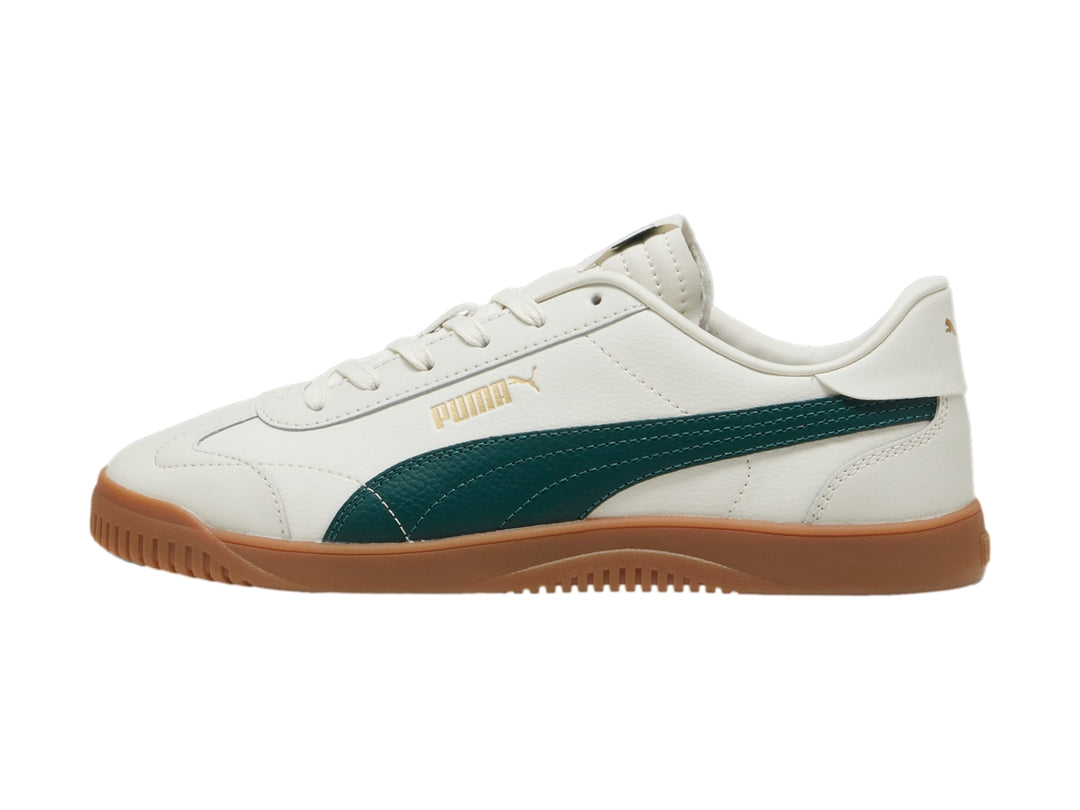 Tenis PUMA Club 5v5 color blanco con franja verde oscuro y suela de goma color café.