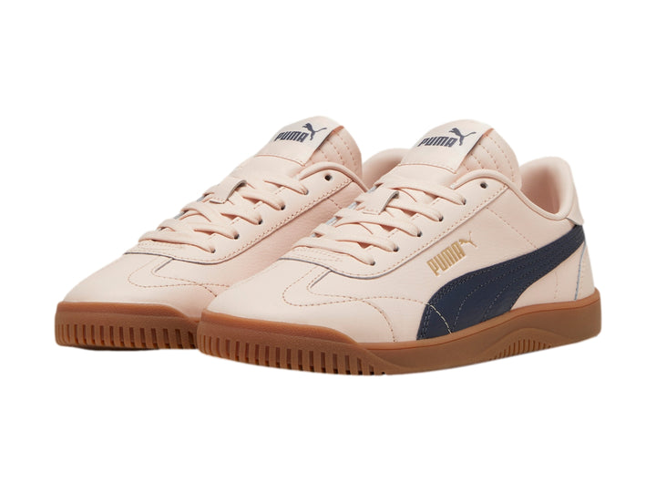 Tenis PUMA color rosa con franja lateral gris oscuro y suela de goma color caramelo.