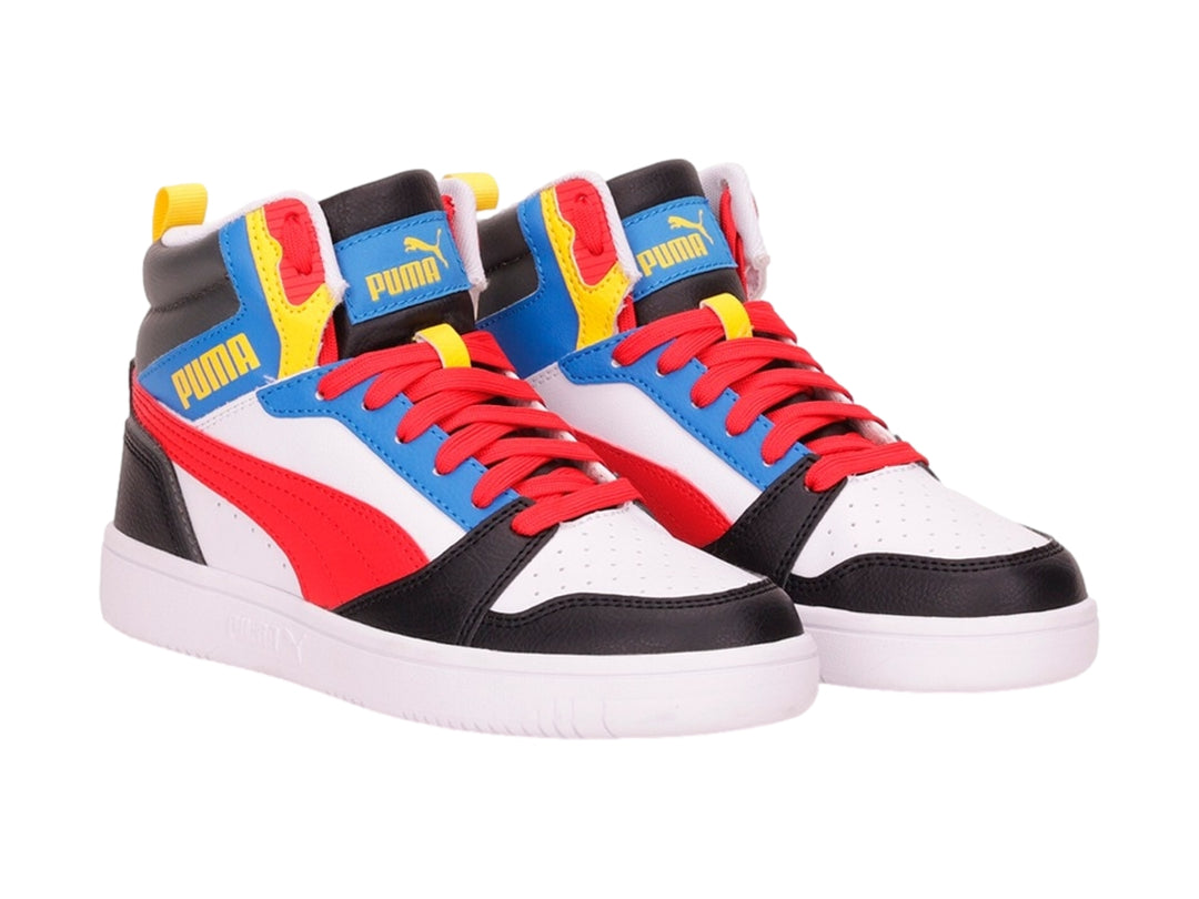 Tenis PUMA Rebound V6 Mid JR multicolores en blanco, rojo, azul y negro con suela blanca.