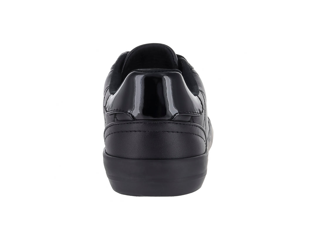 Tenis negros de material sintético con diseño acolchado lateral y suela negra.
