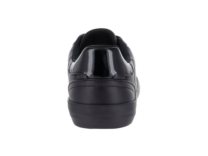Tenis negros de material sintético con diseño acolchado lateral y suela negra.