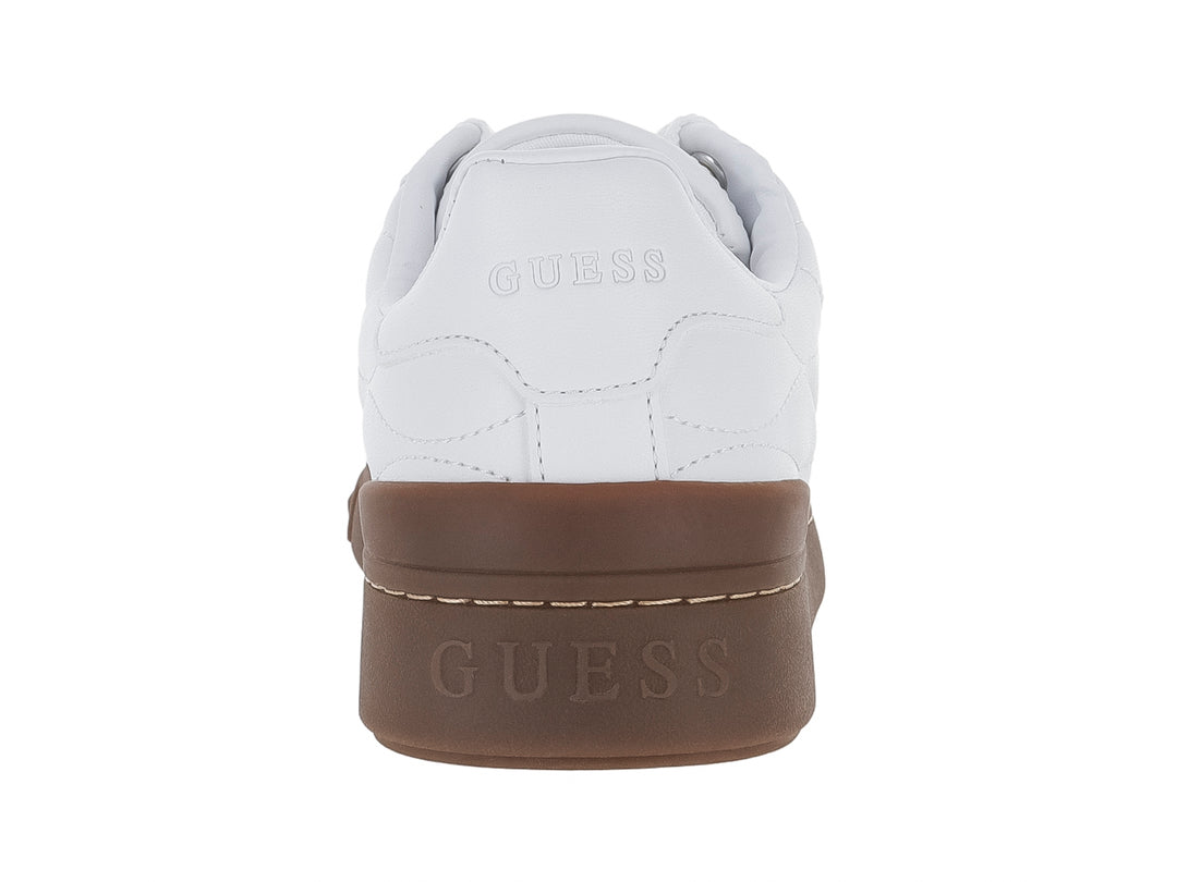 Tenis blancos Guess con textura acolchada, punta gris y suela gruesa color café.
