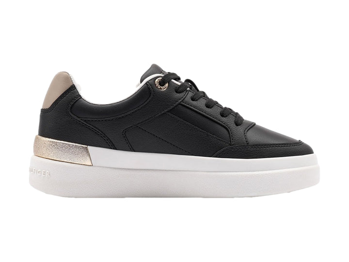 Tenis negros de Tommy Hilfiger con suela blanca y detalles dorados en el talón.