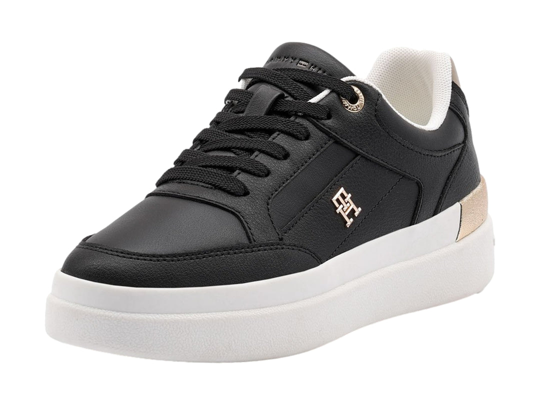 Tenis negros de Tommy Hilfiger con suela blanca y detalles dorados en el talón.