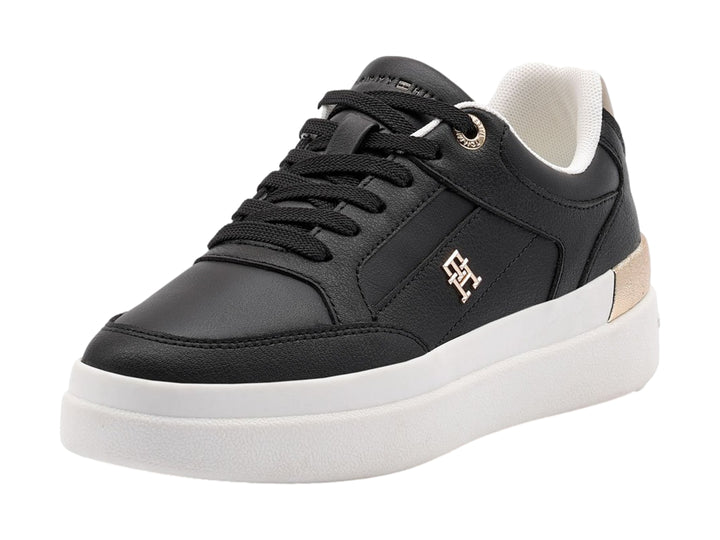 Tenis negros de Tommy Hilfiger con suela blanca y detalles dorados en el talón.
