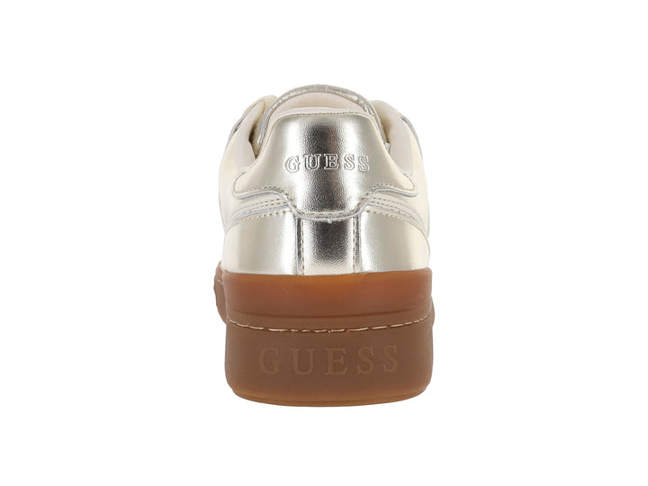Tenis GUESS color dorado metálico con detalles en blanco y suela gruesa color café.