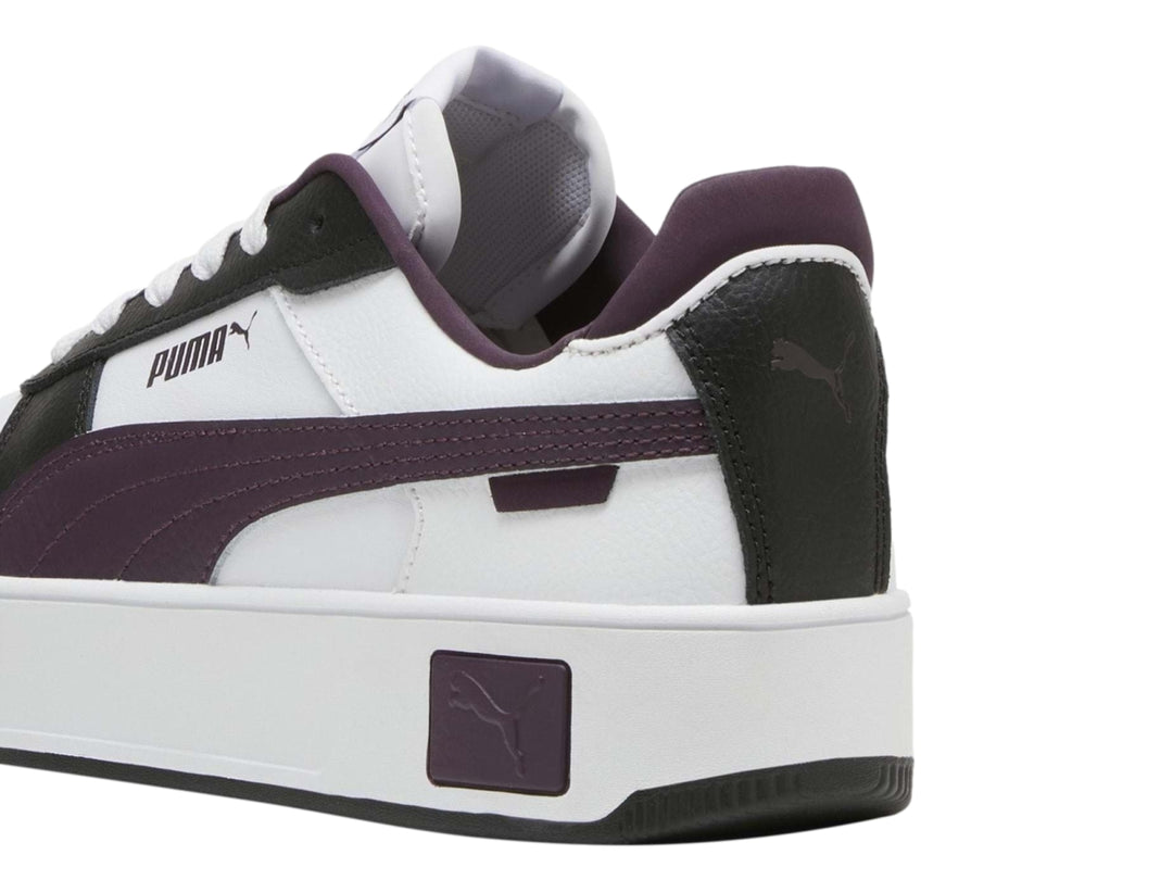 Tenis PUMA Carina Street en color blanco con detalles en morado y negro, con suela de plataforma blanca.