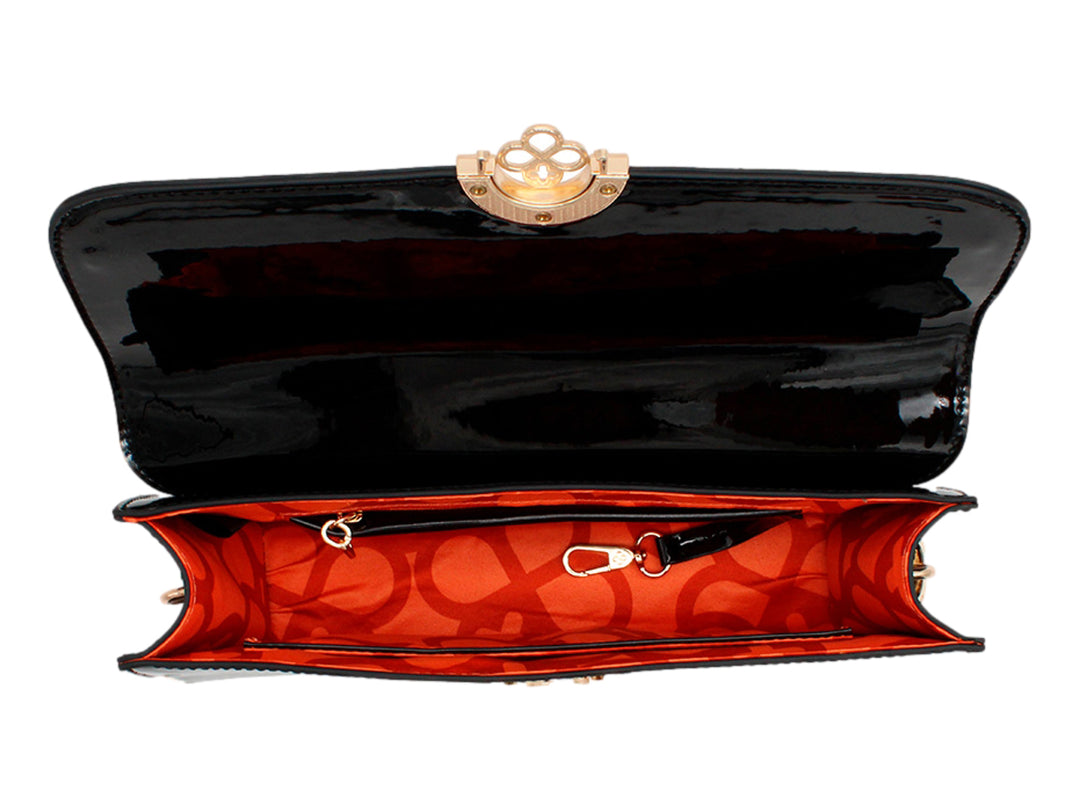 Bolso de mano negro en acabado charol brillante con cierre circular dorado y correa larga.