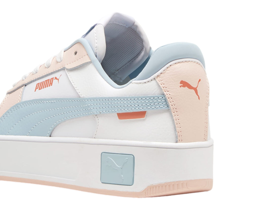 Tenis PUMA Carina Street en color blanco con detalles en azul claro y rosa, con suela de plataforma blanca.