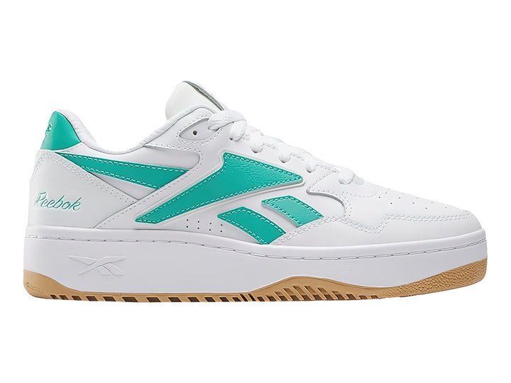 Tenis Reebok blancos con detalles en verde y suela de goma color miel.