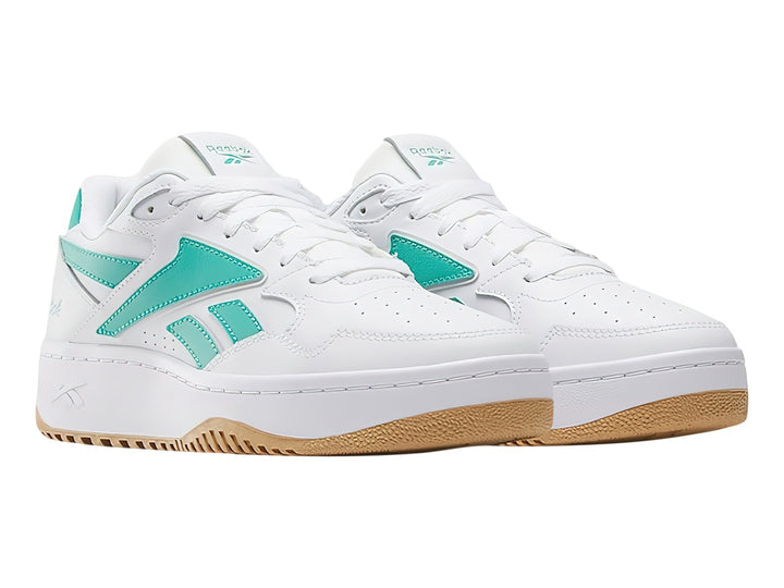 Tenis Reebok blancos con detalles en verde y suela de goma color miel.
