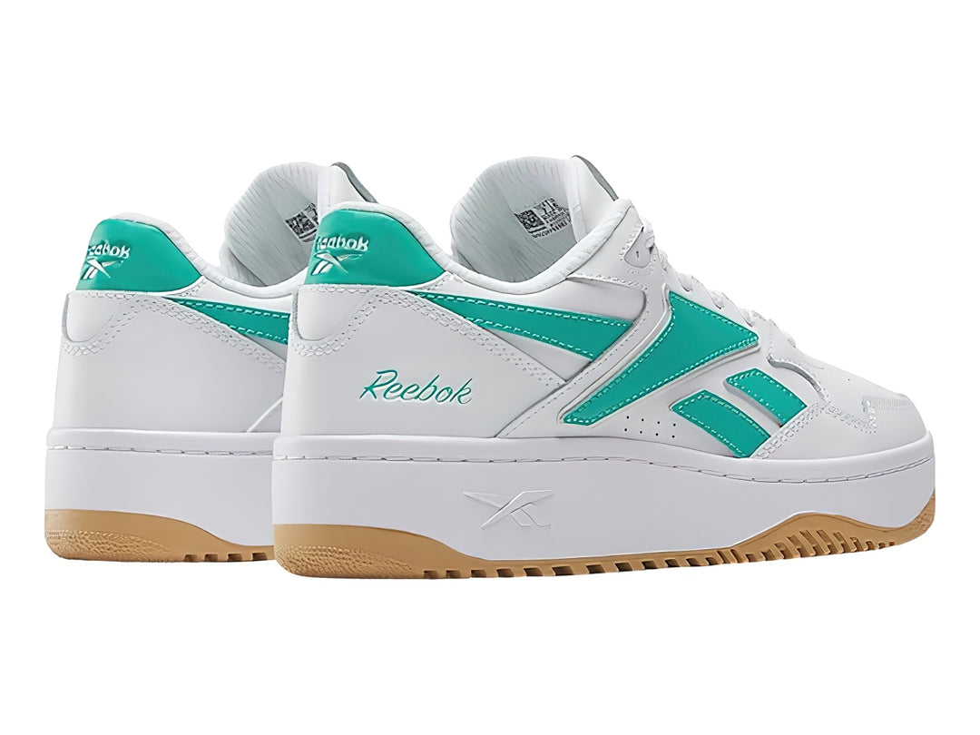 Tenis Reebok blancos con detalles en verde y suela de goma color miel.