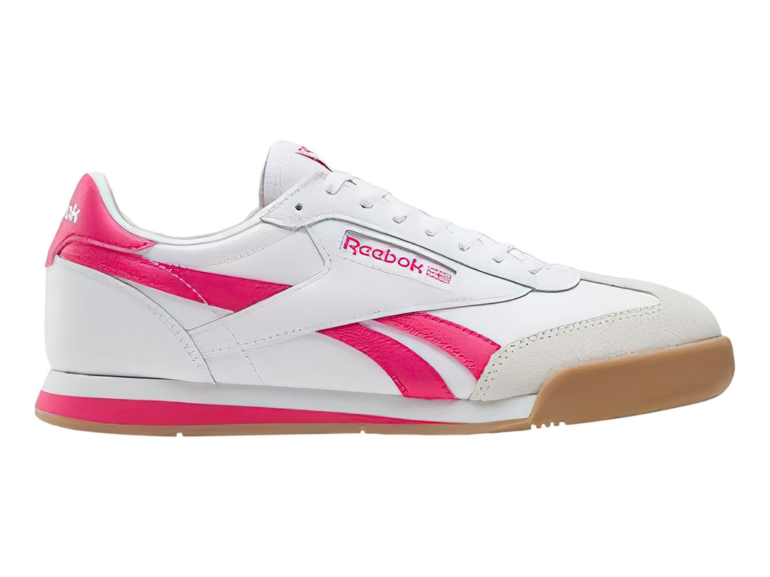 Tenis Reebok blancos con franjas rosas y suela de goma color café.