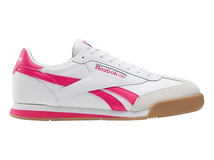 Tenis Reebok blancos con franjas rosas y suela de goma color café.
