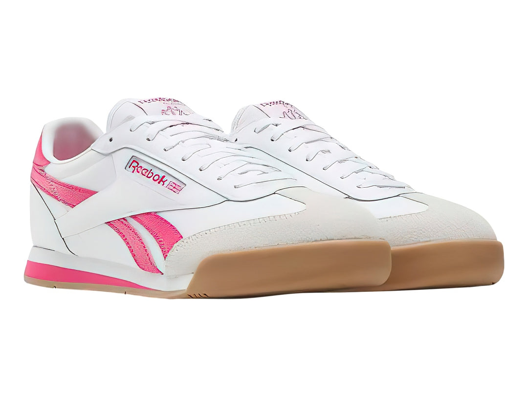 Tenis Reebok blancos con franjas rosas y suela de goma color café.