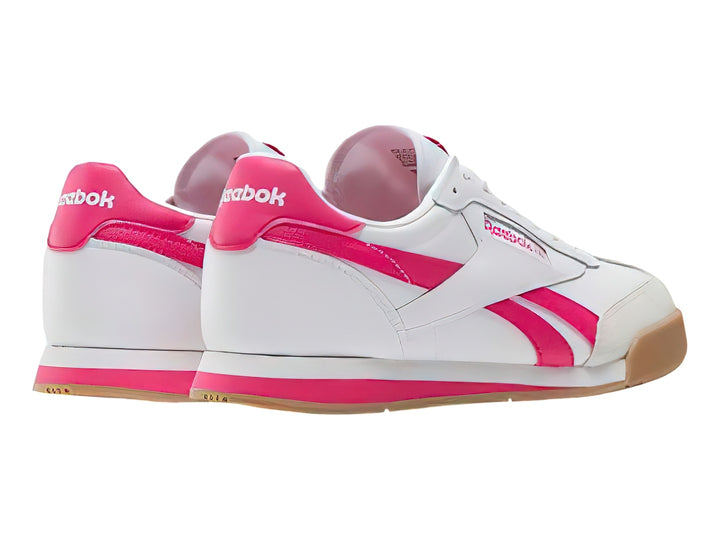 Tenis Reebok blancos con franjas rosas y suela de goma color café.